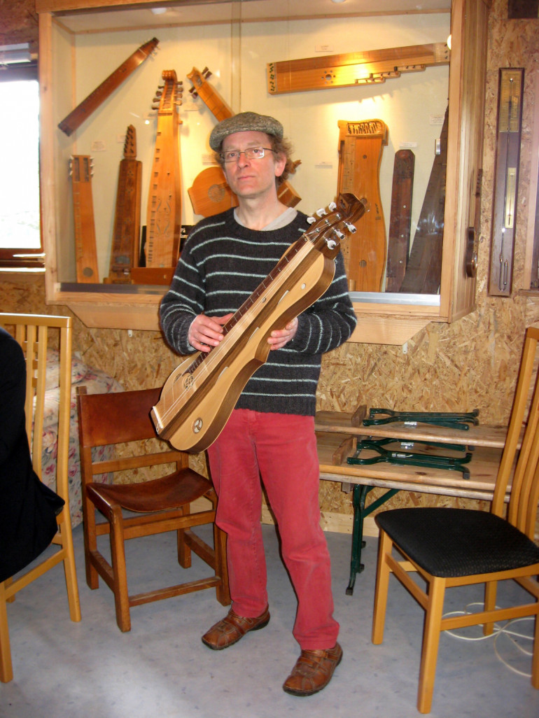 Christophe Toussaint accompagné de l’une de ses épinettes au sein de son atelier.